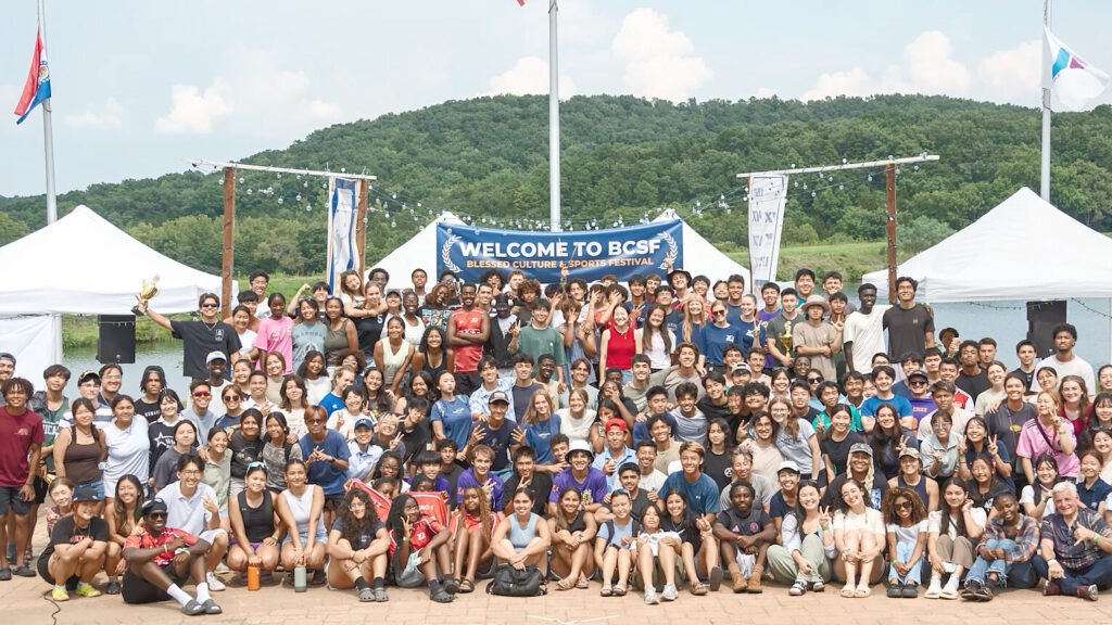 미국 미주리 YMCA 캠프에서 열린 ‘2025 축복문화체육대회’에 참가한 다양한 국적의 청년 약 300명이 환영 현수막 앞에 모여 환하게 웃으며 기념 촬영을 하고 있다.
