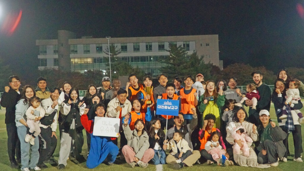 ‘2025 신한국 미래세대 피스컵’ 경기에서 우승한 대전충남교구 선수들과 가족, 응원단이 우승 트로피를 들고 환호하며 단체 기념촬영을 하고 있다.
