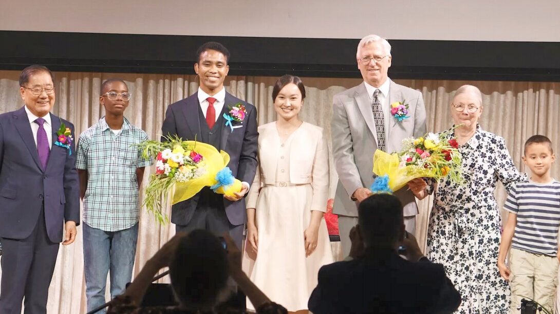 미국 라스베이거스 가정교회 담임목사 이·취임 예배에서 전임·신임 목회자 부부와 가족들이 꽃다발을 들고 무대 위에서 기념 촬영을 하고 있다.